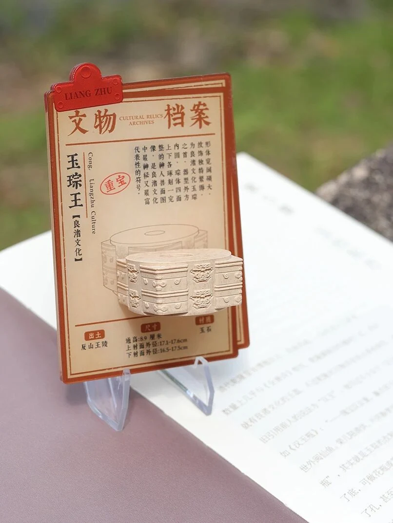 官方实物图：玉琮王小件、档案底板与透明支脚。