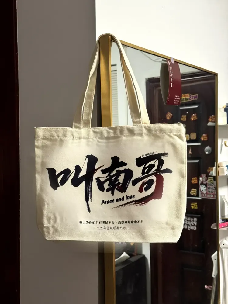 原创作者实拍：米白帆布包上的黑红大字与小号英文。